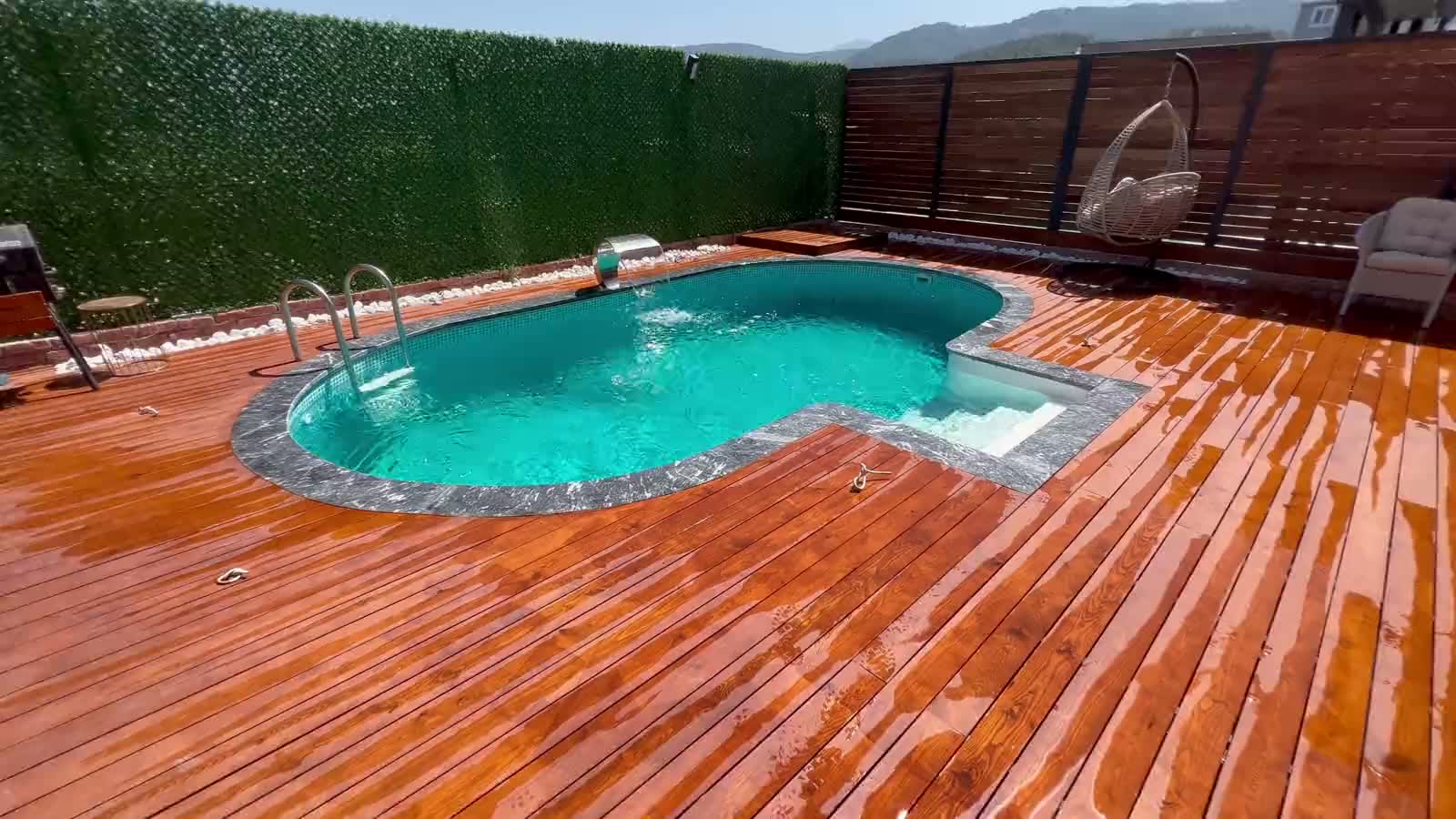 Maldiv oval havuz ve çevresindeki ahşap deck, kuşbakışı