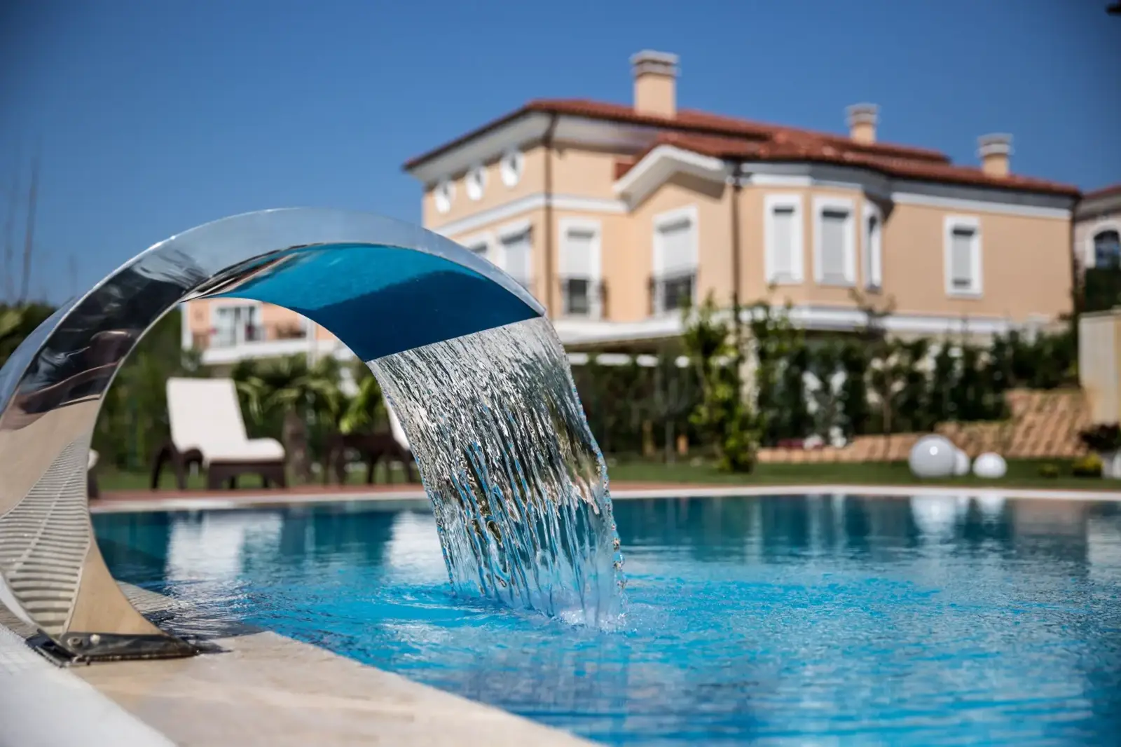 Villa bahçesinde şelaleli, tamamlanmış dikdörtgen havuz