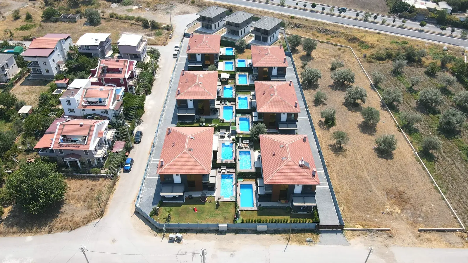 Villa sitesinde sıra villalara ait havuzlar, kuşbakışı