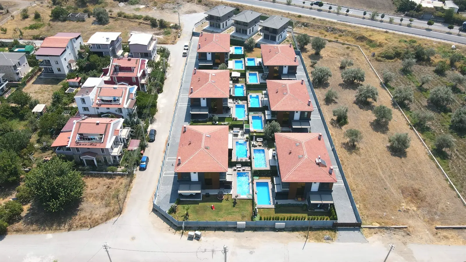 Villa sitesinde sıra villalara ait havuzlar, kuşbakışı