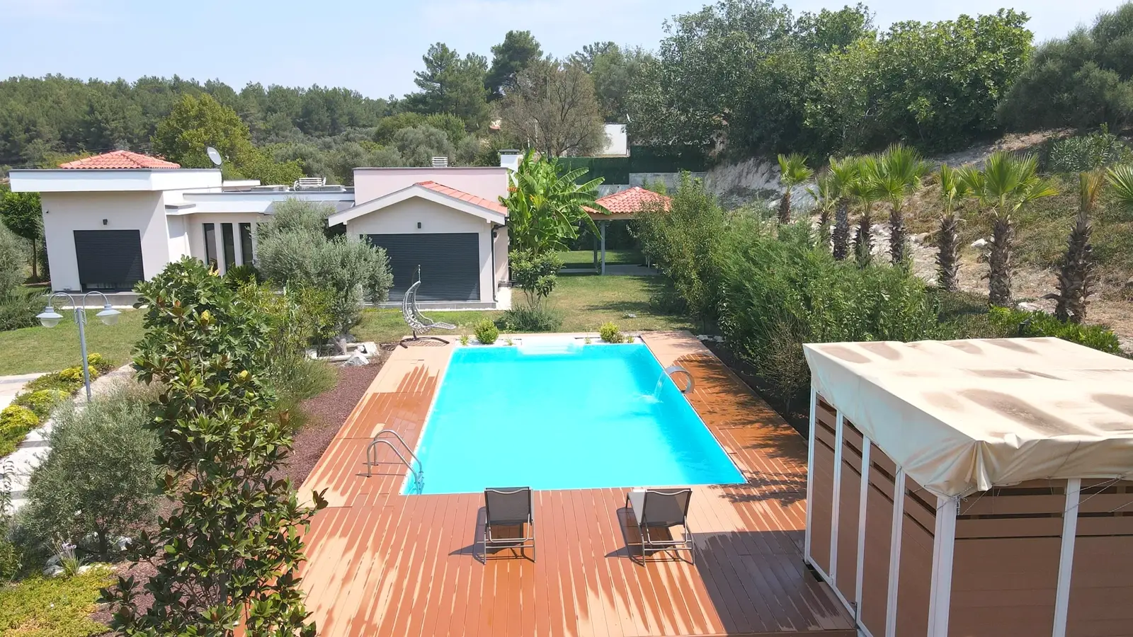 Villa bahçesinde ahşap deckli havuz