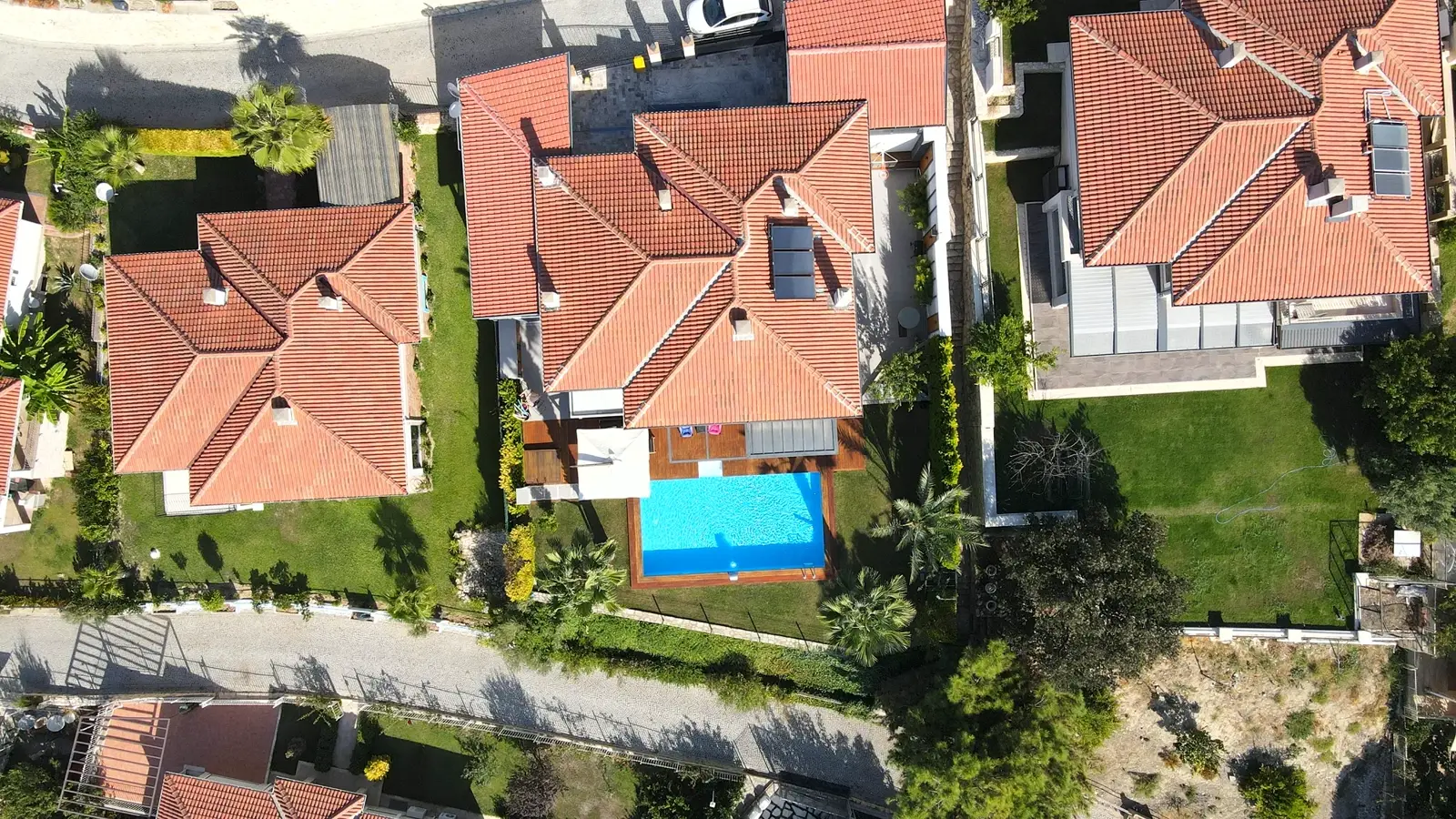 Kırmızı çatılı villalar arasında bahçe havuzu