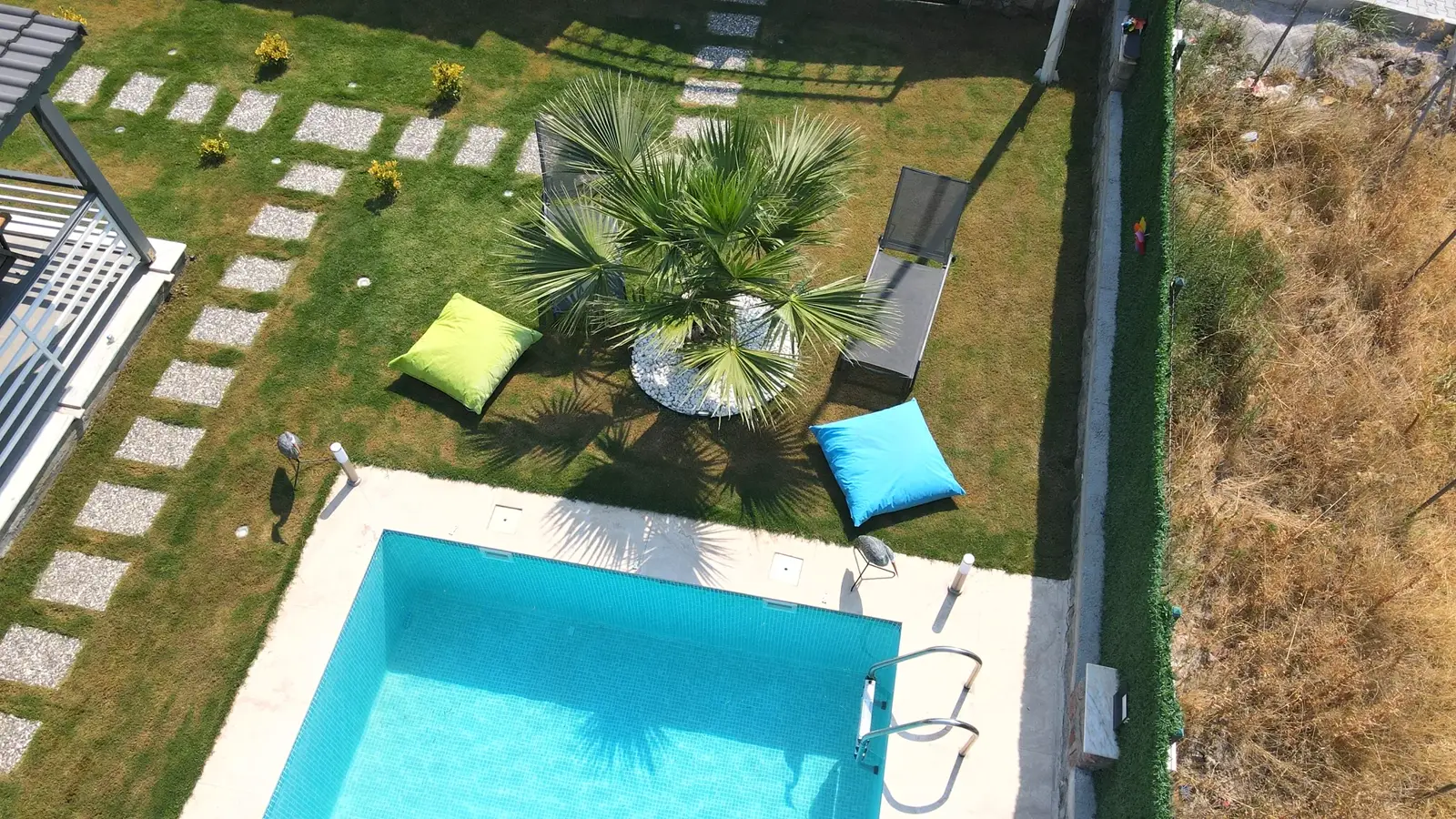 Modern villa bahçesinde çim zeminli havuz düzeni
