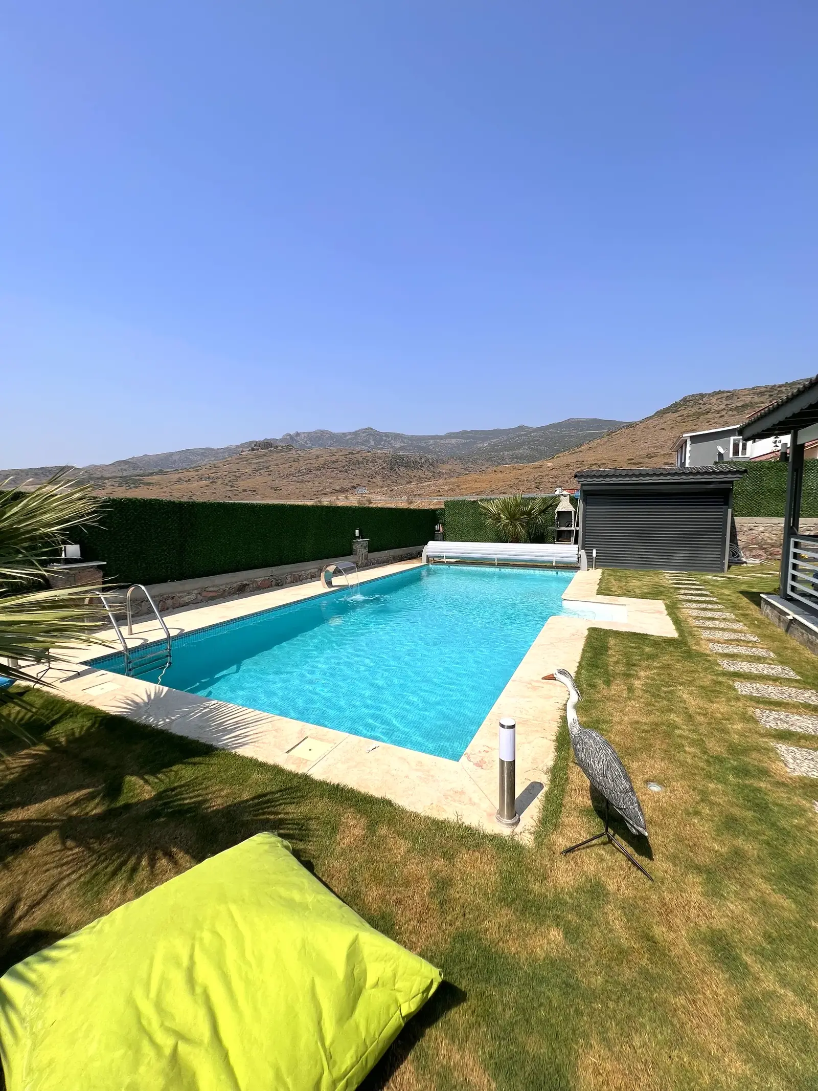 Modern villa bahçesinde çim zeminli havuz düzeni