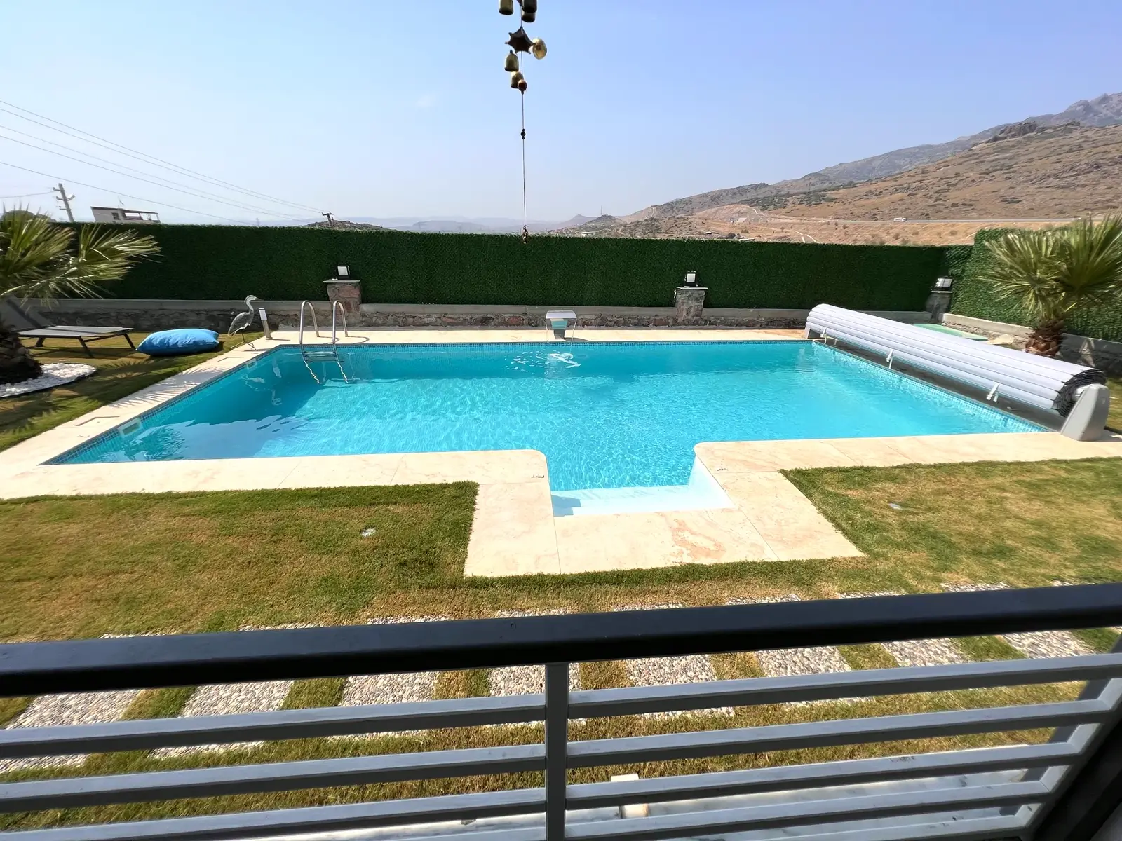 Modern villa bahçesinde çim zeminli havuz düzeni