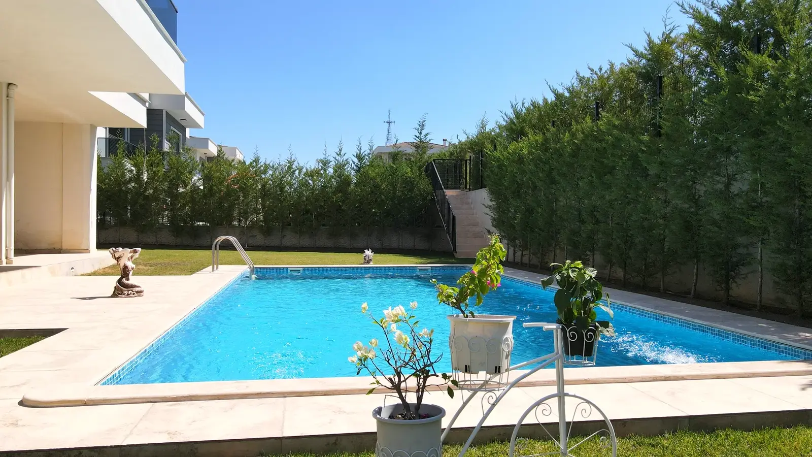 Modern villa bahçesinde havuz ve oturma alanı