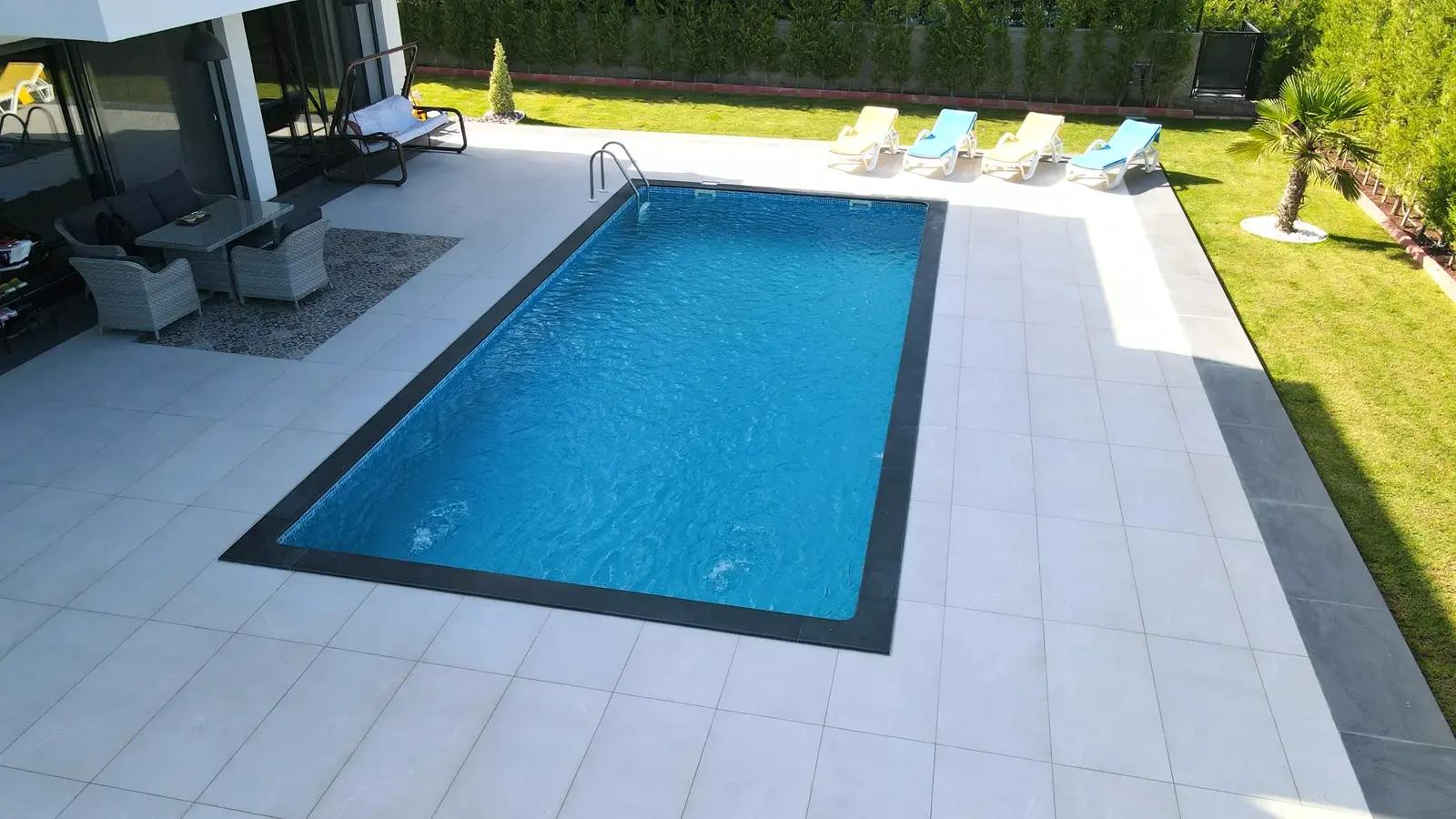 Modern villa bahçesinde havuz ve oturma alanı